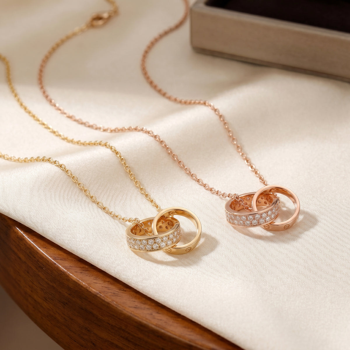 Gold and rose gold Interlocking Circle Pendant Necklaces displayed together on soft fabric