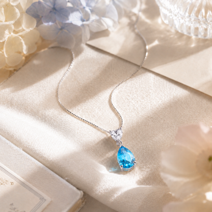 925 sterling silver blue teardrop heart necklace styled with flowers and a romantic note, an elegant gift for her