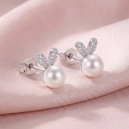 925 sterling silver pearl bunny stud earrings with polished silver ears and soft pearl accents on pink fabric