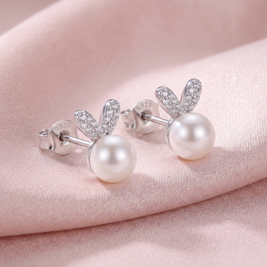 925 sterling silver pearl bunny stud earrings with polished silver ears and soft pearl accents on pink fabric