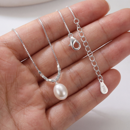 Hand holding 925 sterling silver teardrop pearl pendant necklace showing pearl size and chain detail