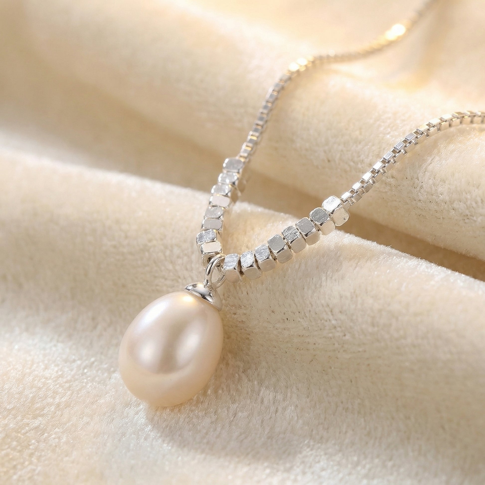 Close up of 925 sterling silver teardrop pearl pendant necklace with delicate chain