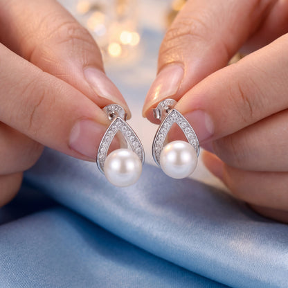 Handheld 925 sterling silver pearl teardrop stud earrings showing white pearls, silver posts and sparkling teardrop detail