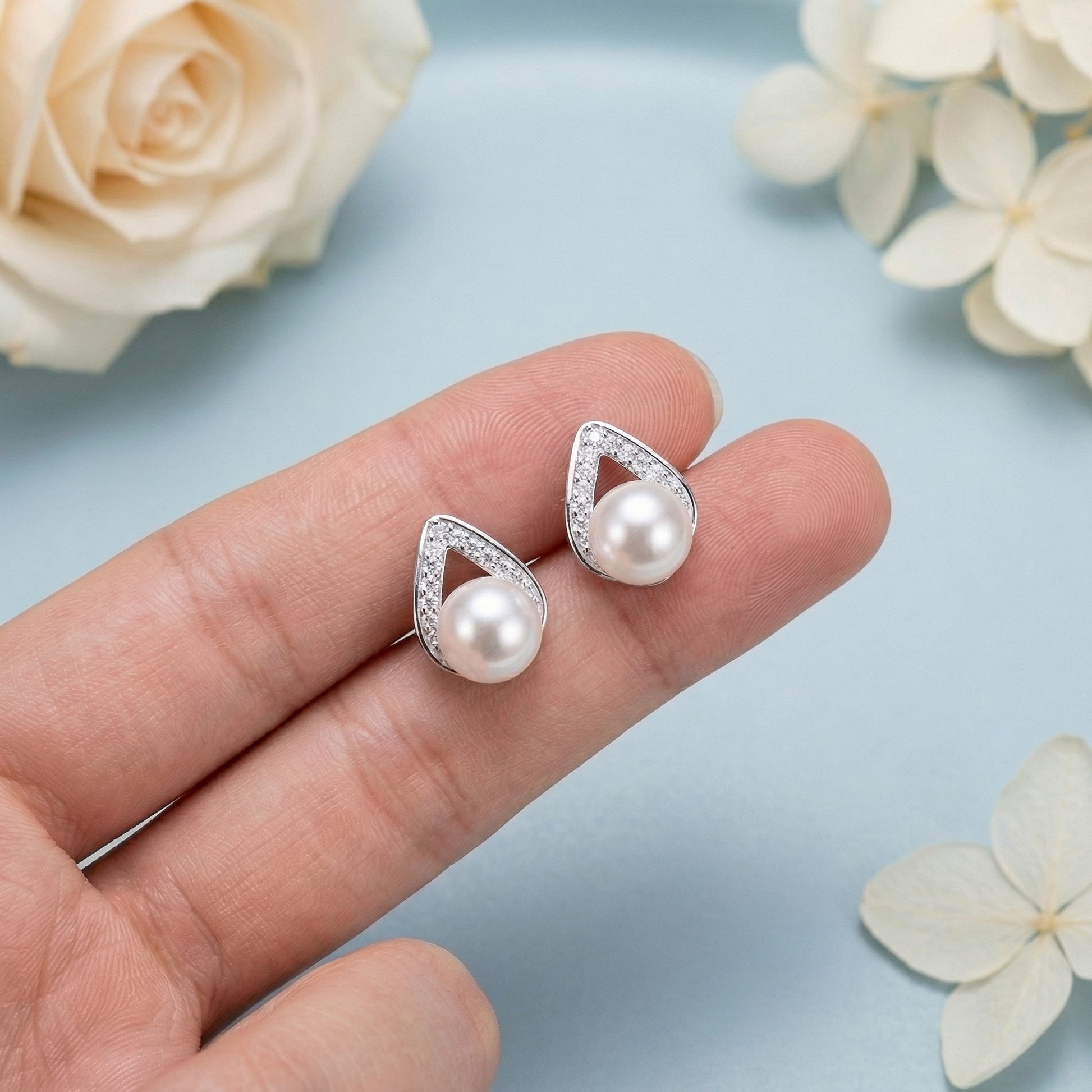 925 sterling silver pearl teardrop stud earrings shown in hand for size reference