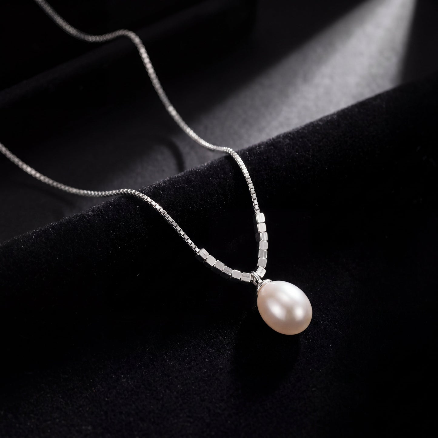 925 sterling silver teardrop pearl pendant necklace photographed on black fabric background
