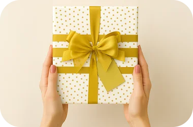 Gift box with a yellow ribbon held by hands on a beige background