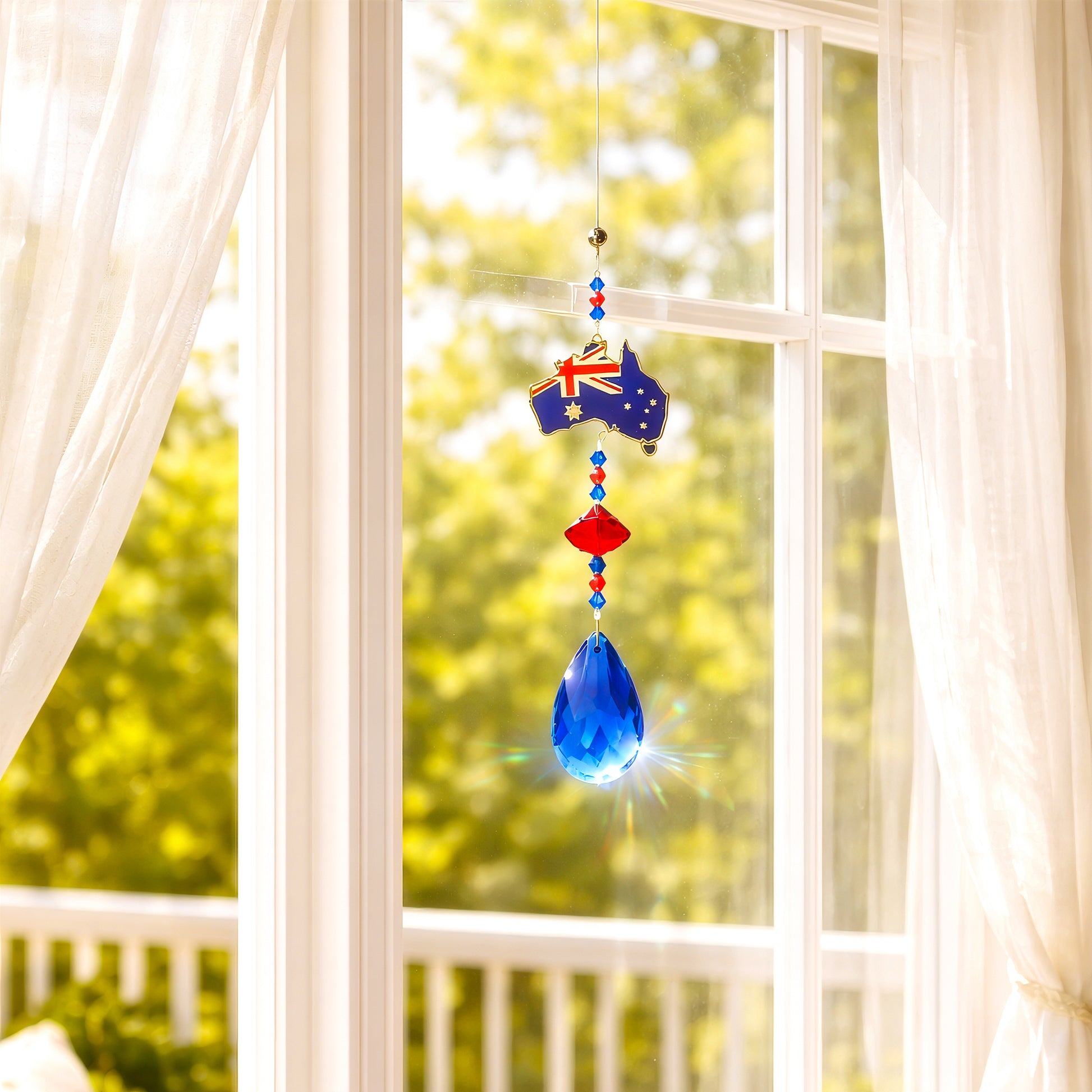Sun catcher with Australia design creating rainbow light reflections near window