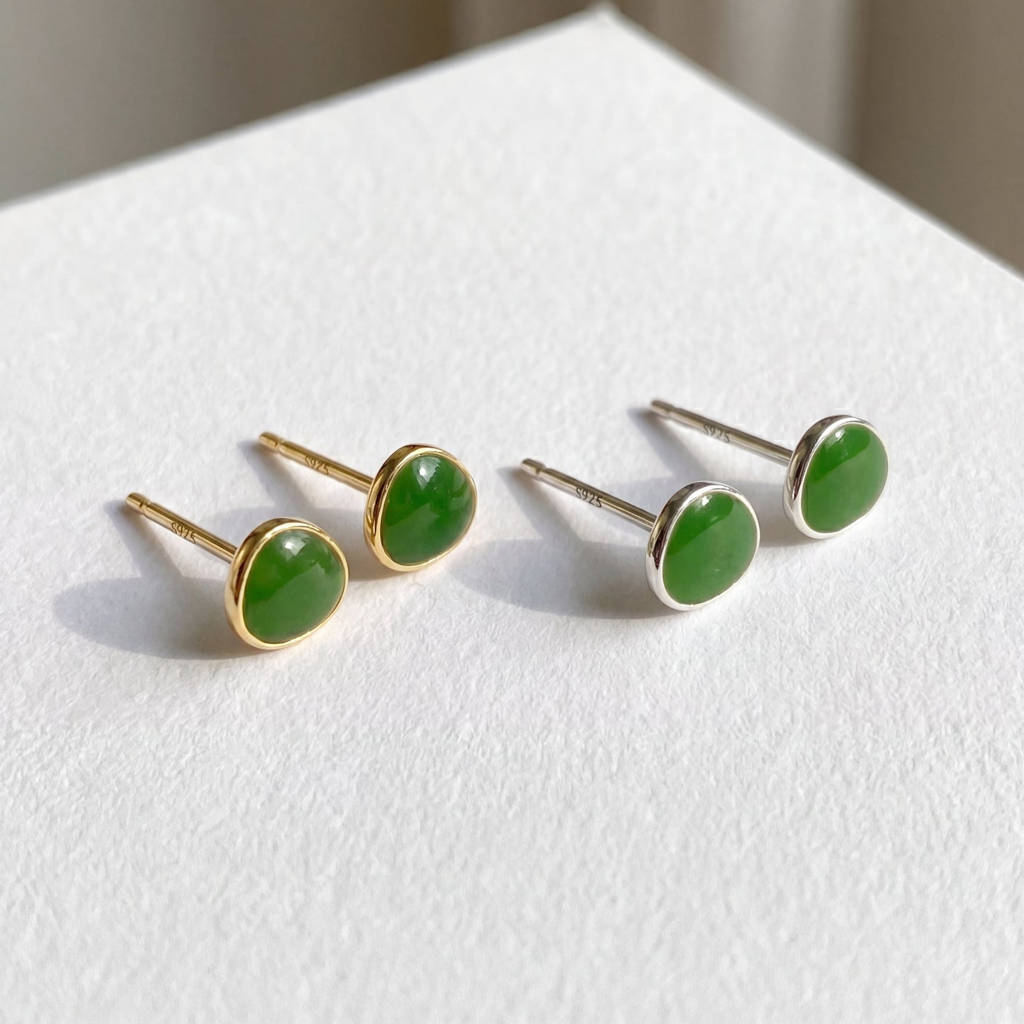 Gold and silver avocado green 925 sterling silver stud earrings displayed together