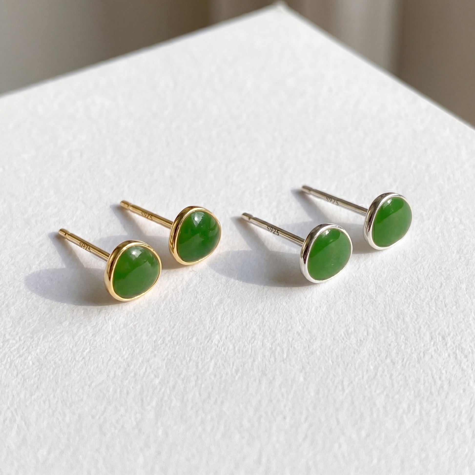 Gold and silver avocado green 925 sterling silver stud earrings displayed together