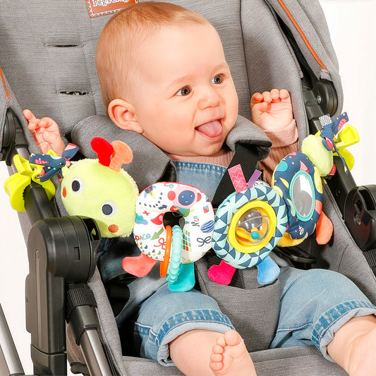 Baby smiling with caterpillar pram chain toy attached to stroller sensory newborn toy
