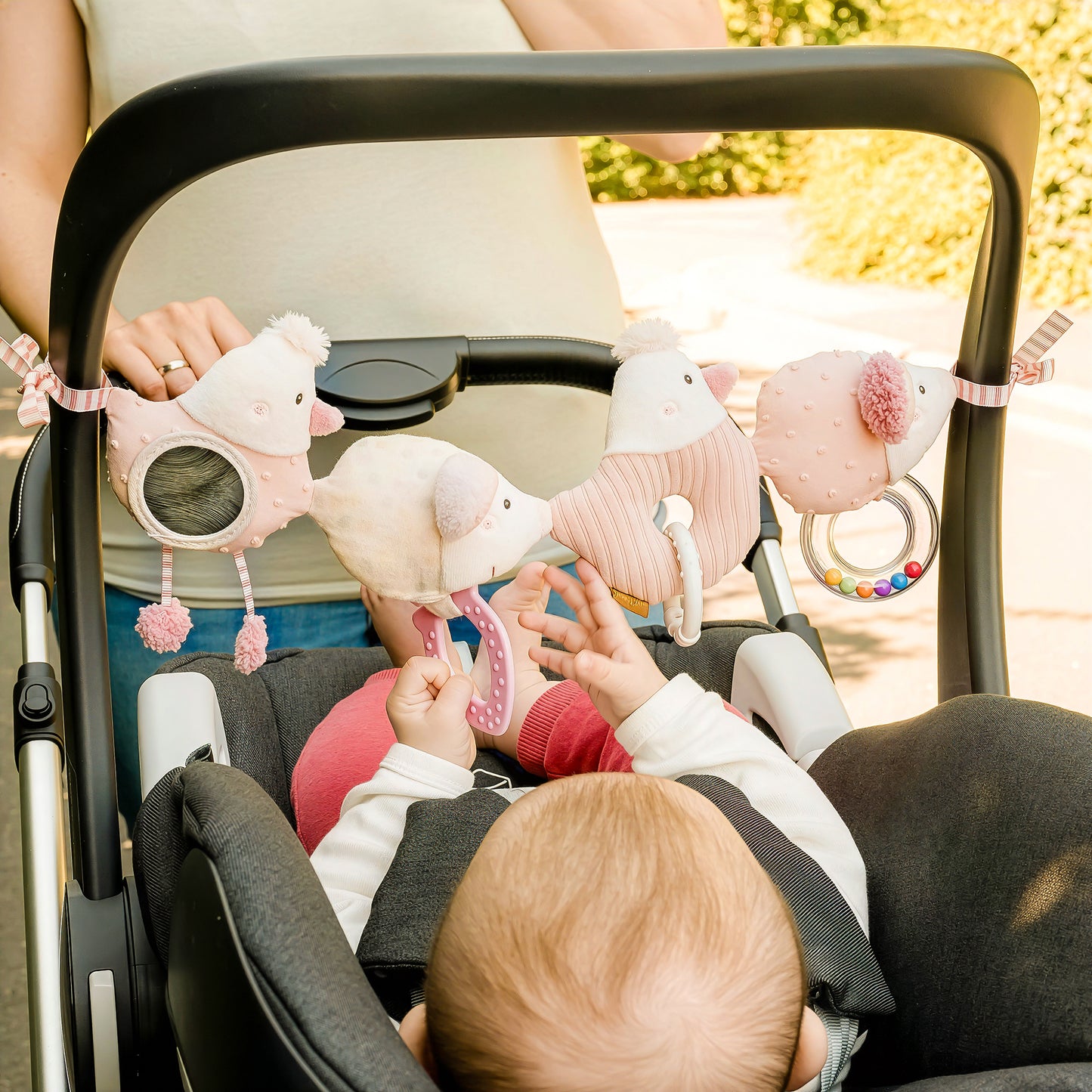 Baby playing with fairy pram chain toy attached to stroller activity toy