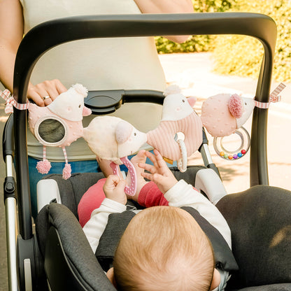 Baby playing with fairy pram chain toy attached to stroller activity toy