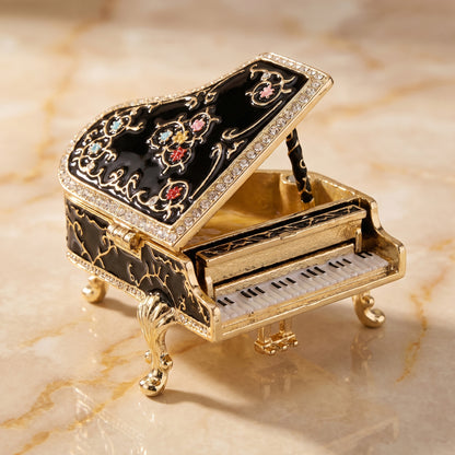Black vintage inspired piano jewellery box with open lid, gold tone legs and decorative enamel details.