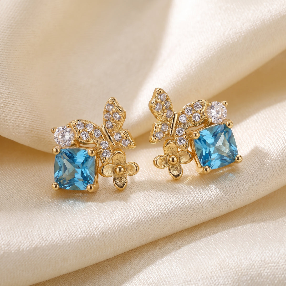 Close-up of blue Gold Butterfly Garden stud earrings with sparkling stones