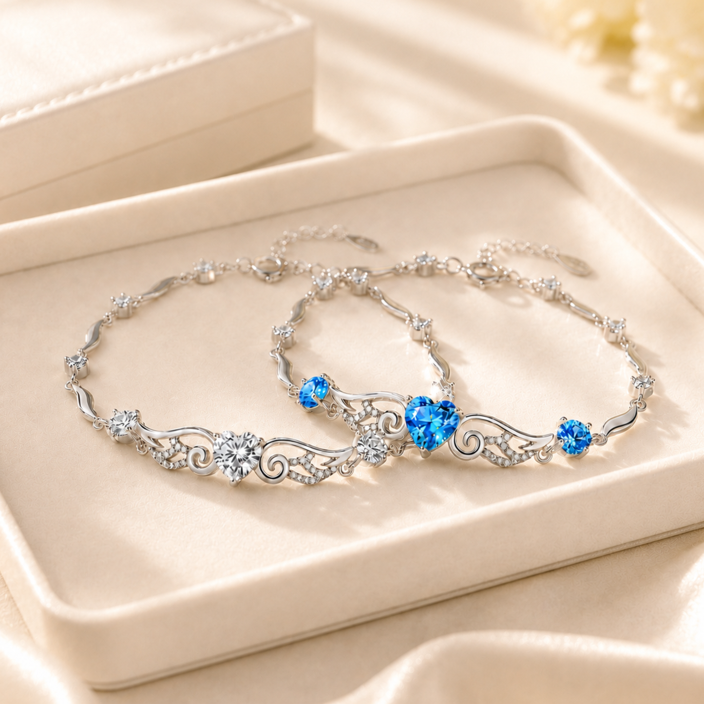 Blue and clear cubic zirconia angel wings heart bracelets displayed together on a jewellery plate