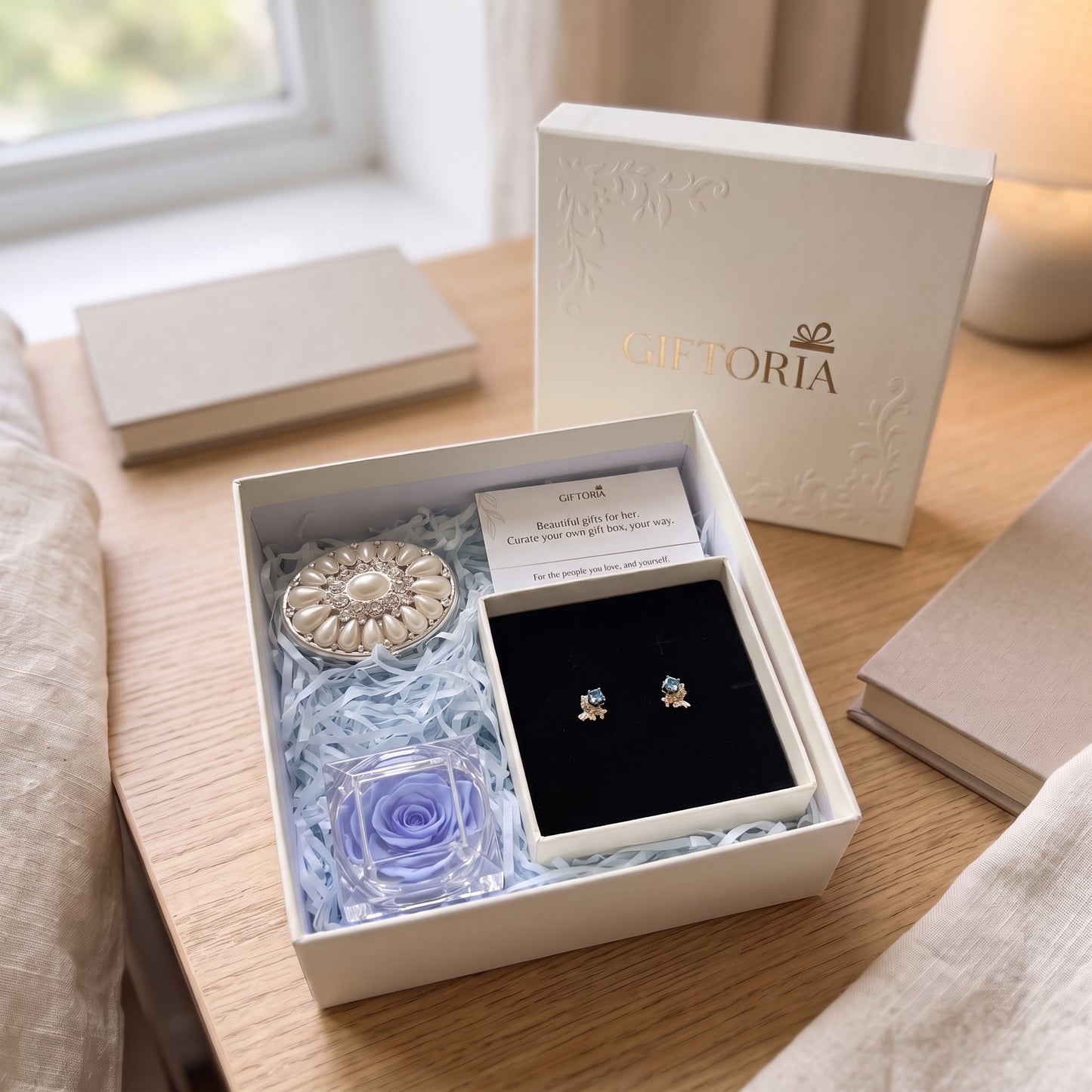 Giftoria butterfly earrings, blue preserved rose and pearl jewellery box gift set on a wooden bedside table