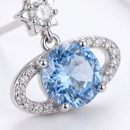 Close-up of a Blue Rose Saturn silver stud earring showing the faceted blue centre stone and surrounding clear stones.
