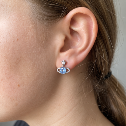 Blue Rose Saturn silver stud earring worn on an ear, showing its size and Saturn-inspired design.