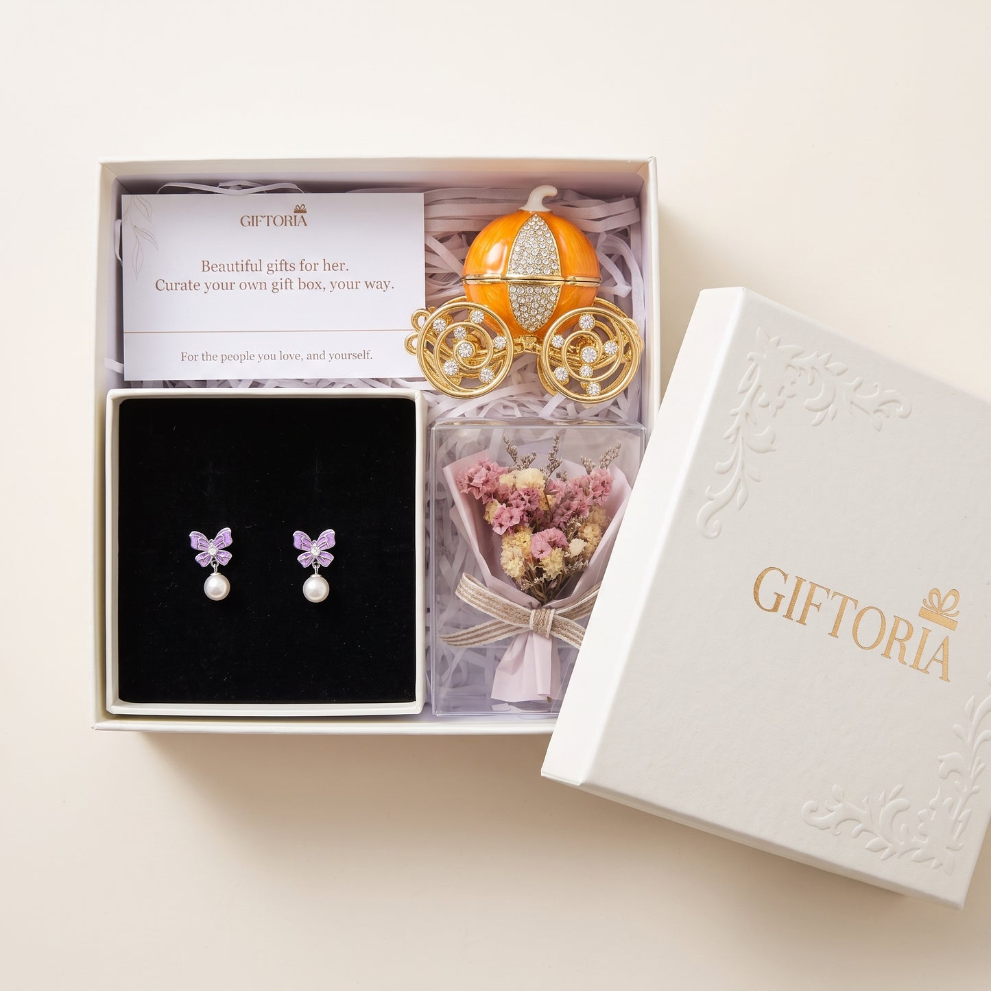 Open gift box with butterfly pearl earrings, dried flowers and a pumpkin carriage jewellery box