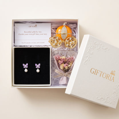 Open gift box with butterfly pearl earrings, dried flowers and a pumpkin carriage jewellery box