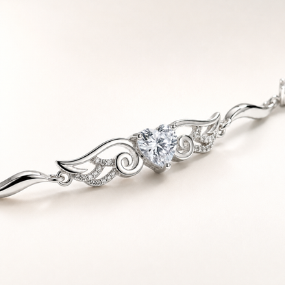 Close-up of the clear cubic zirconia heart and angel wing design on a sterling silver bracelet