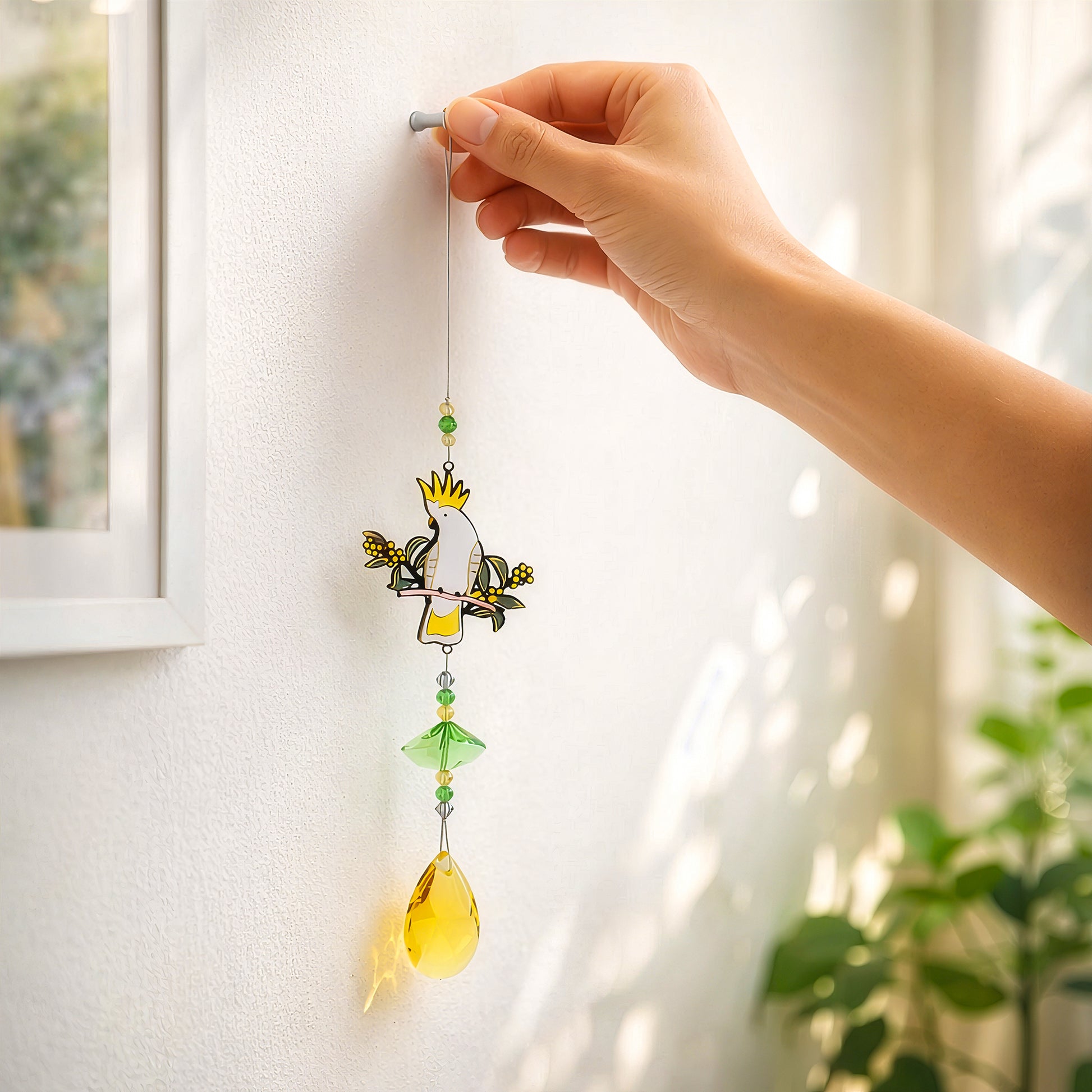 Cockatoo sun catcher shown hanging on wall 