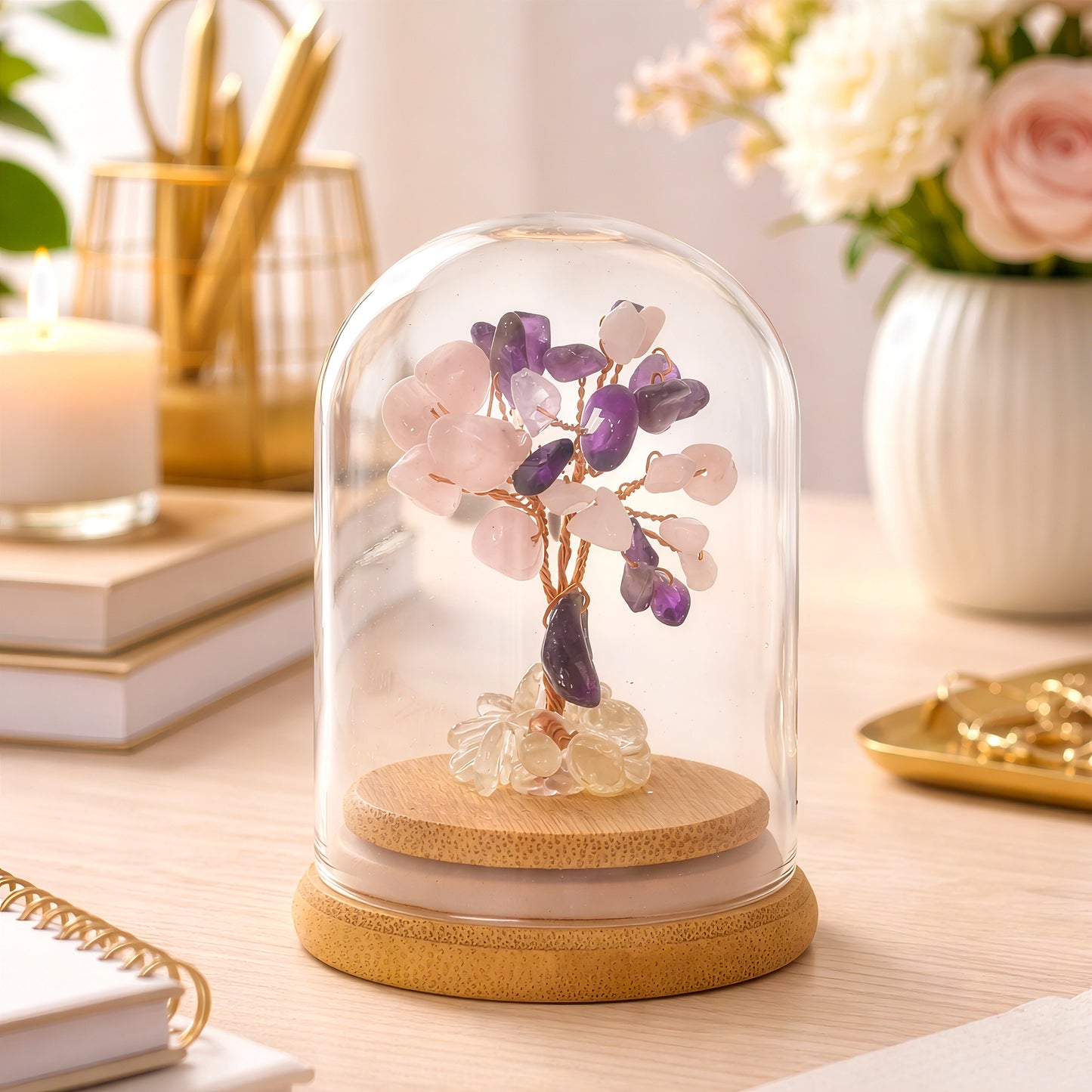 Elegant crystal tree symbolising love and compassion styled on desk with candle and flowers