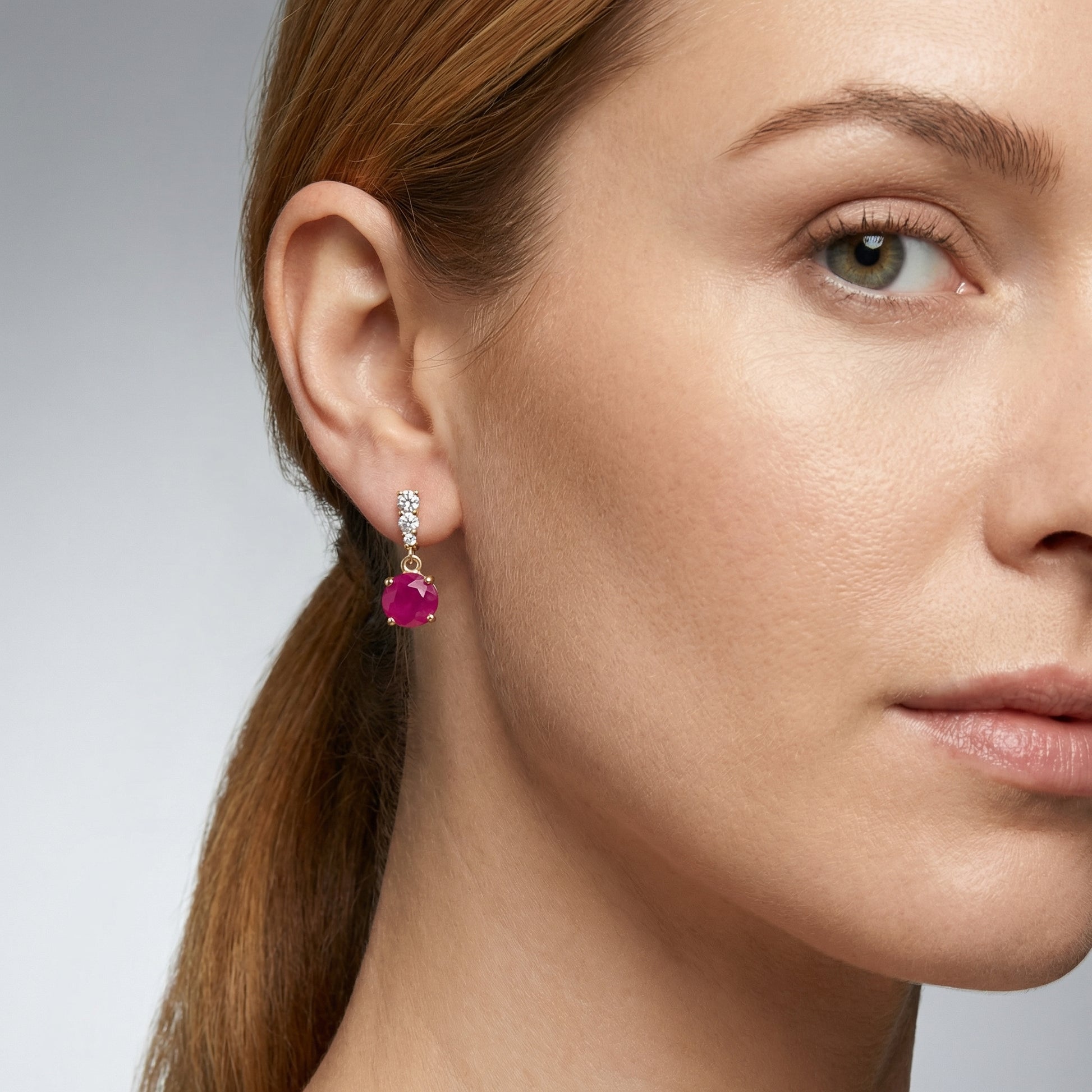 Woman wearing 18K gold plated 925 sterling silver red cubic zirconia drop stud earrings