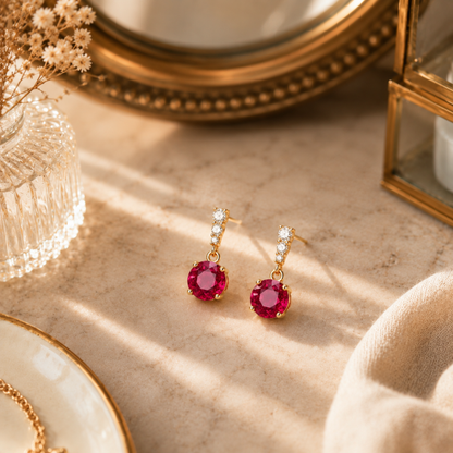 Elegant ruby red earrings styled on a warm dressing table