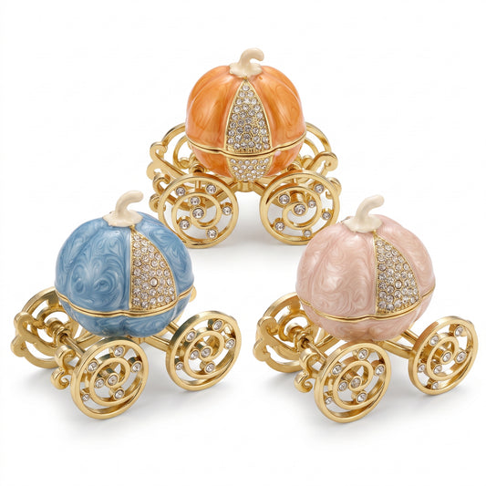 Three Enchanted Pumpkin Carriage Jewellery Box with gold wheels and crystal details in a white background.