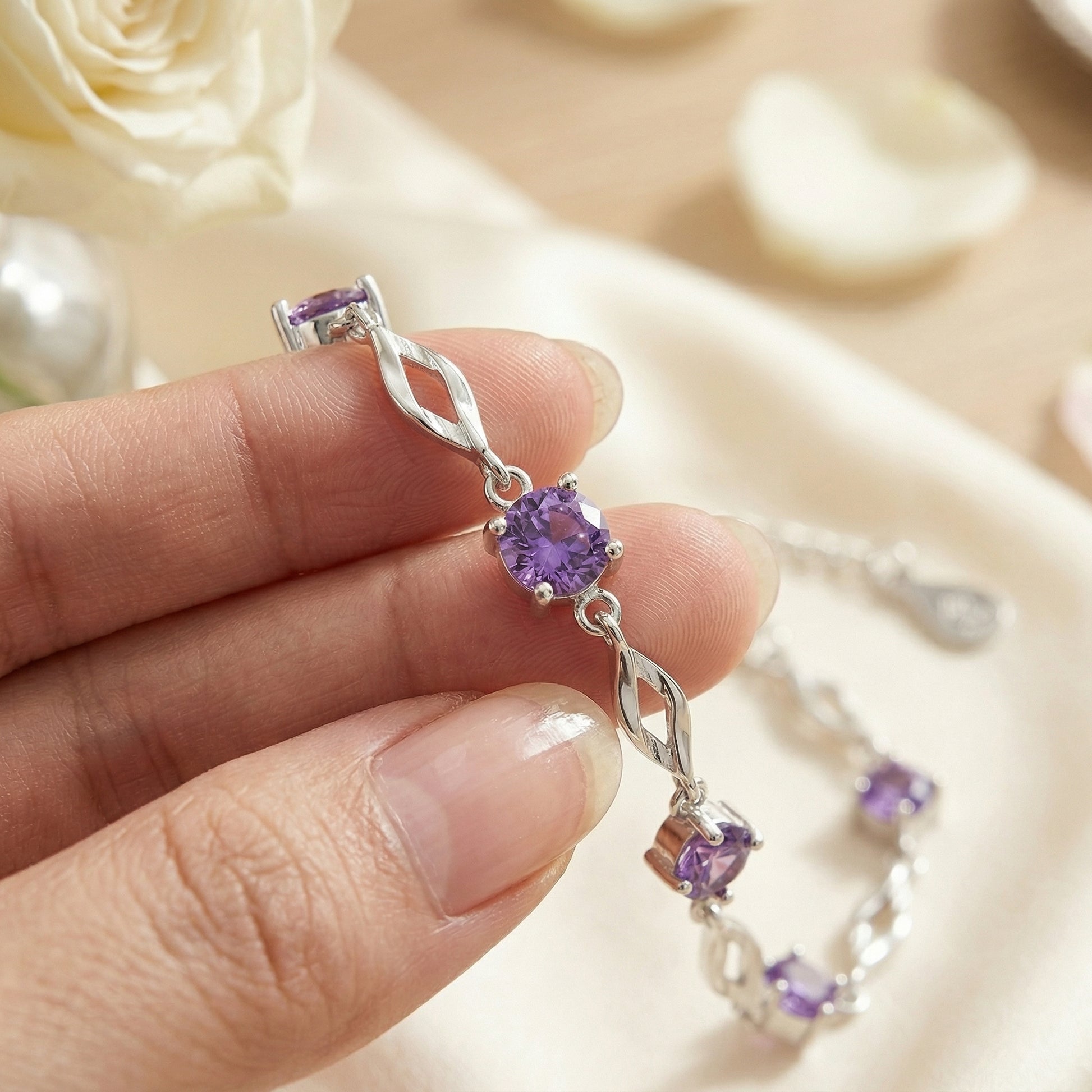 Close up of purple cubic zirconia 999 fine silver bracelet with elegant twisted chain design