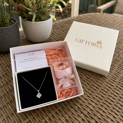 Four leaf clover necklace and dried rose gift box displayed on an outdoor table