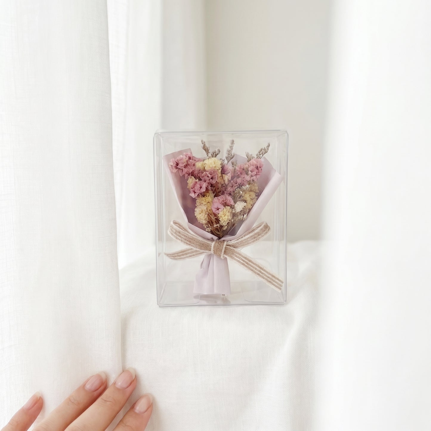 Pink mixed dried flower bouquet box beside curtains, soft feminine preserved flower gift for her