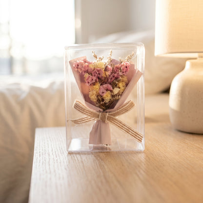 Pink mixed dried flower bouquet box on coffee table, elegant ready-to-gift floral arrangement