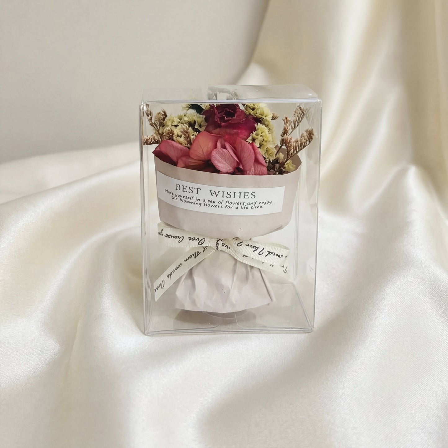 Red rose dried flower bouquet box on white silk fabric, romantic gift-ready flower box