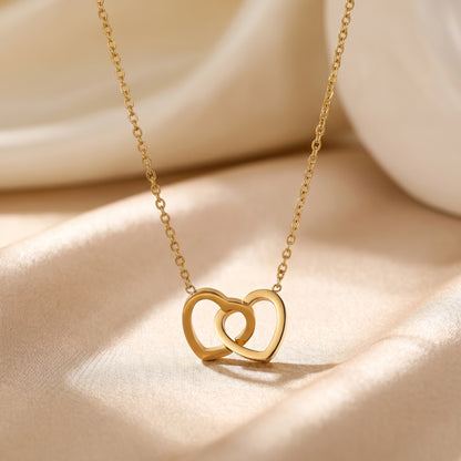Gold interlocking double heart necklace styled on champagne satin as a romantic jewellery gift for her