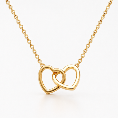 Gold stainless steel interlocking double heart necklace with delicate chain displayed on a white background