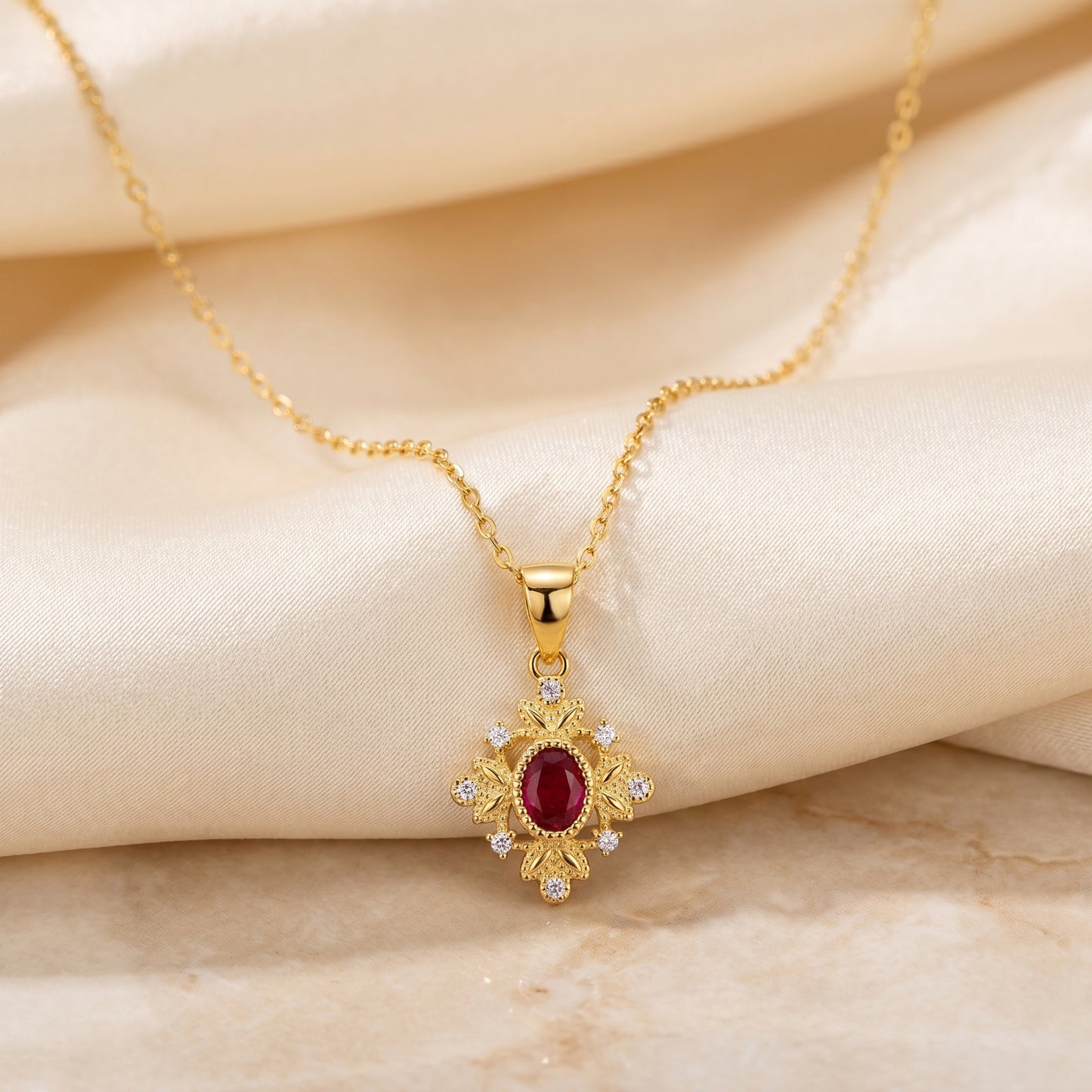 Full view of a gold 925 sterling silver ruby red vintage pendant necklace on soft ivory fabric