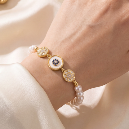 Gold Sunburst Evil Eye Pearl Bracelet worn on a woman’s wrist