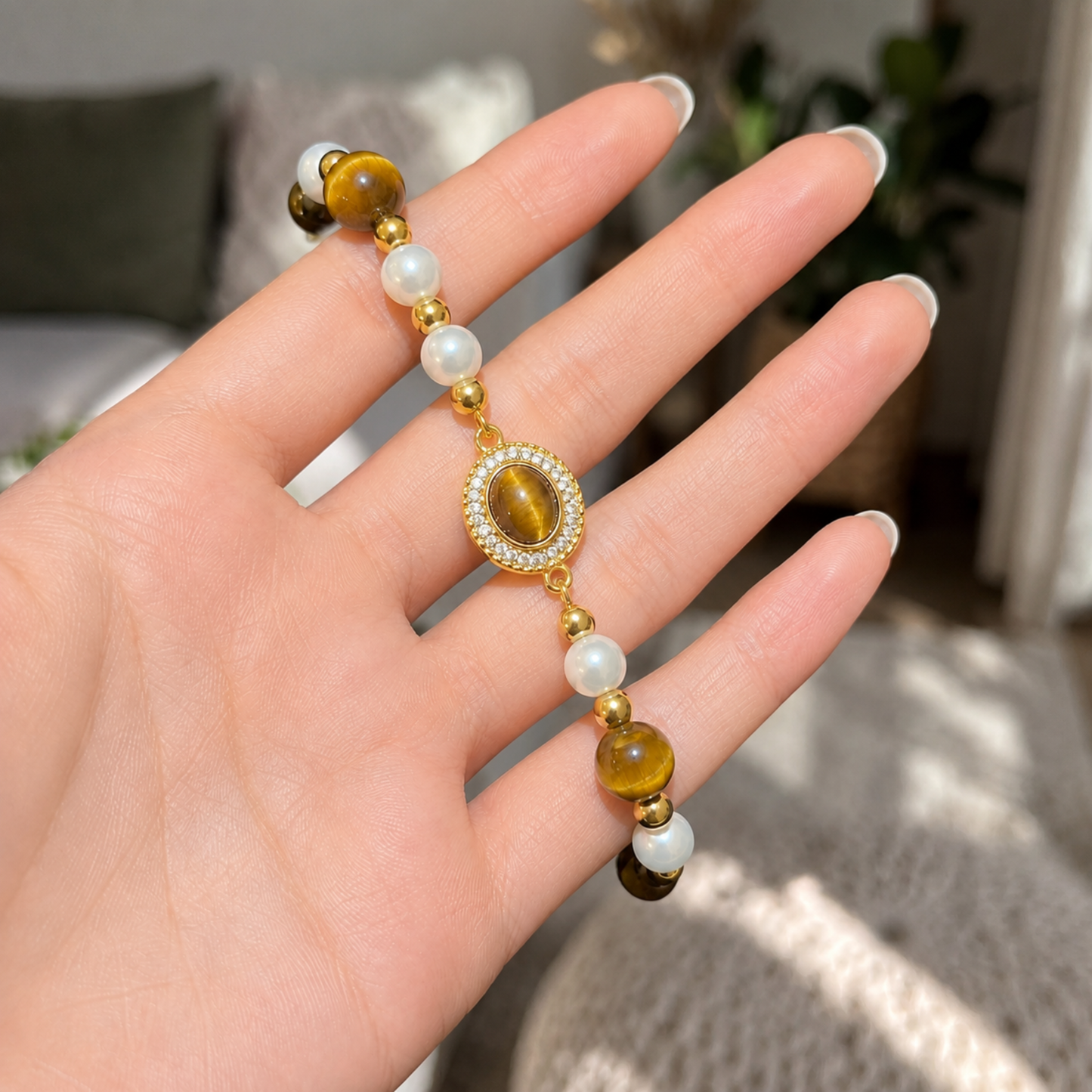 Gold Tiger Eye Pearl Halo Bracelet held in hand showing the tiger eye and pearl details