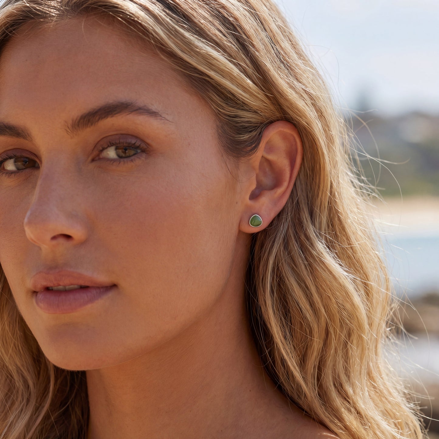 Avocado green 925 sterling silver stud earrings shown on ear for a delicate everyday jewellery look