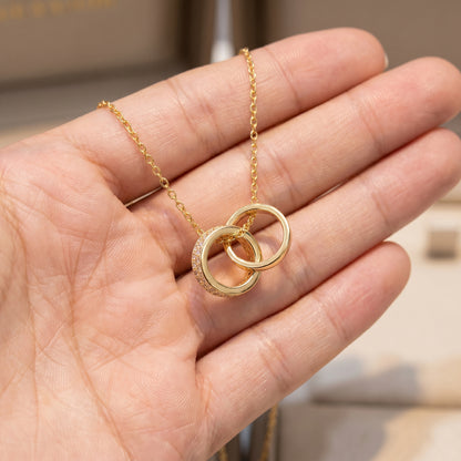 Interlocking Circle Pendant Necklace shown in hand to display pendant size and delicate chain detail
