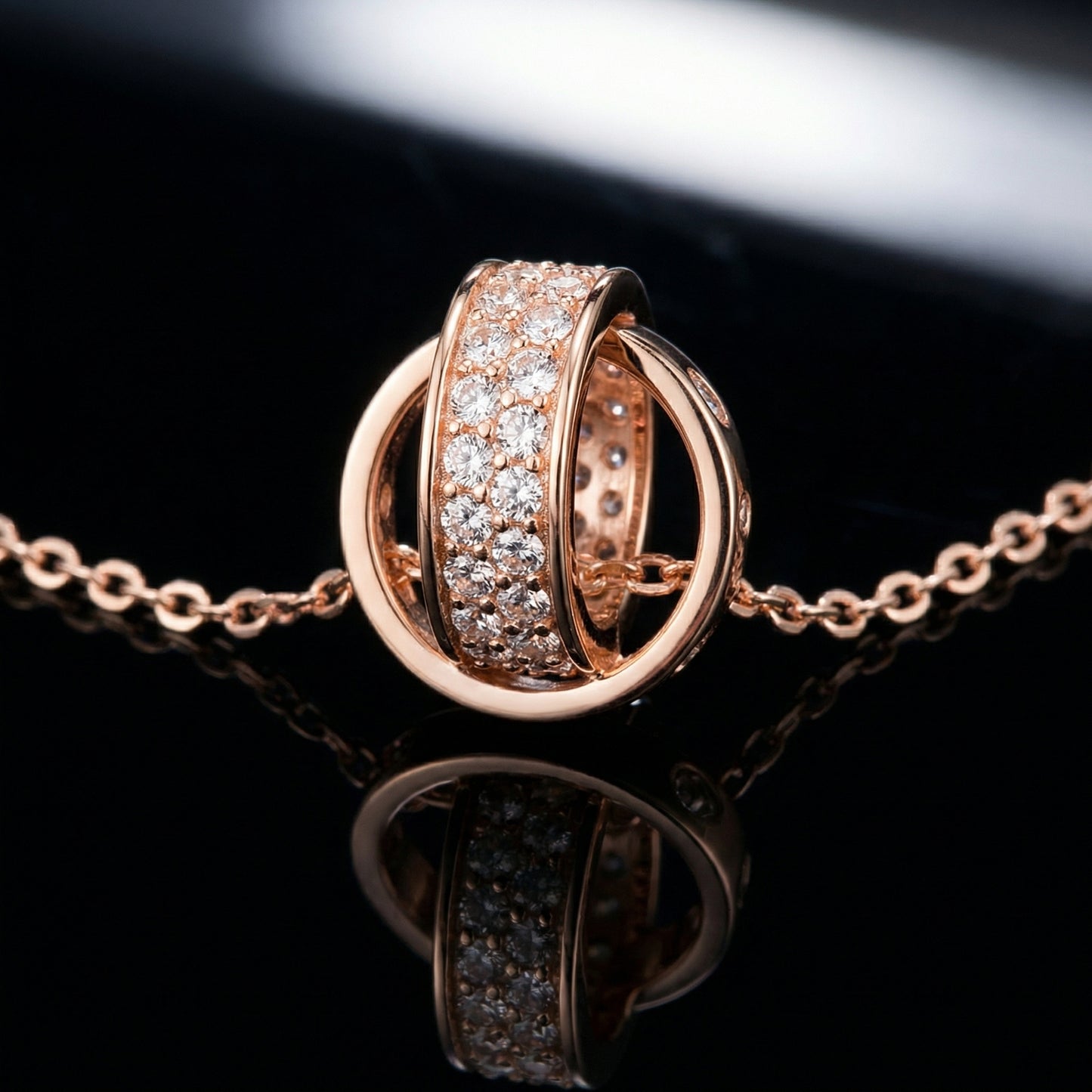 Rose gold Interlocking Circle Pendant Necklace with sparkling crystal detail on black background