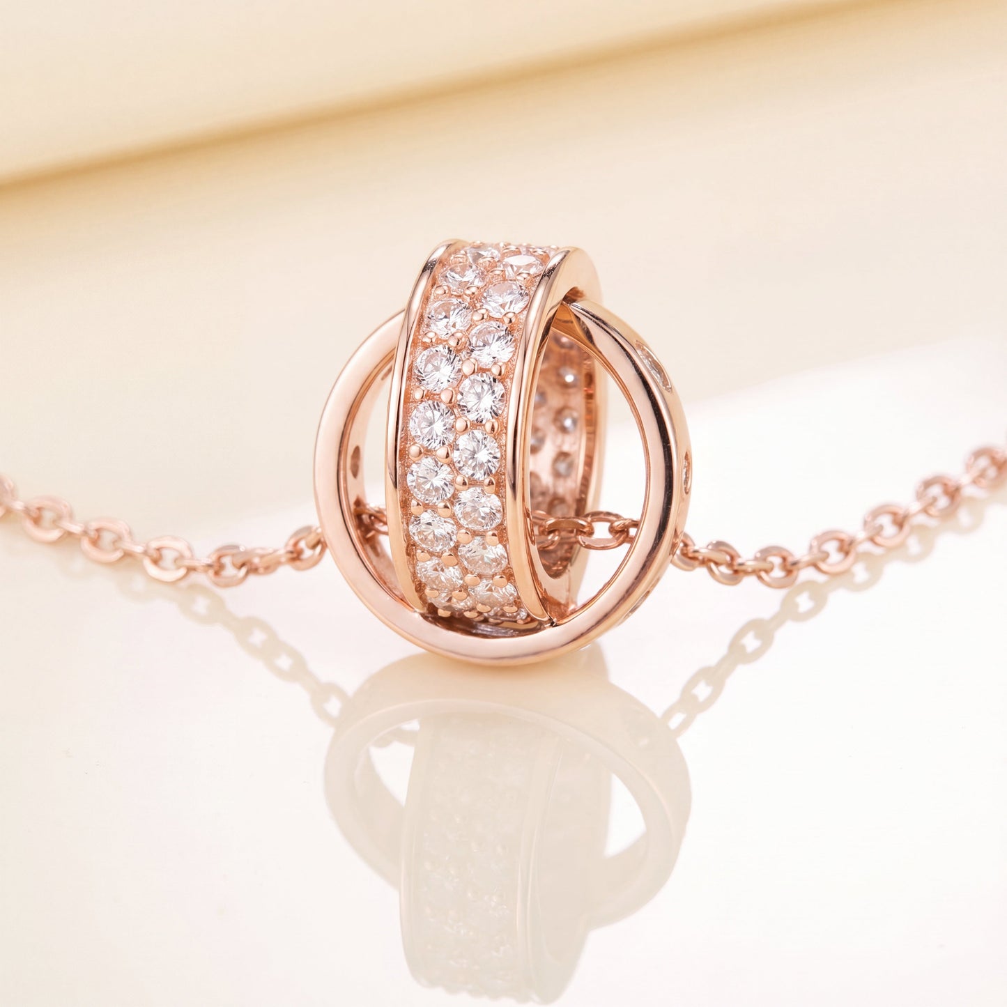 Rose gold Interlocking Circle Pendant Necklace with sparkling crystal detail on white background