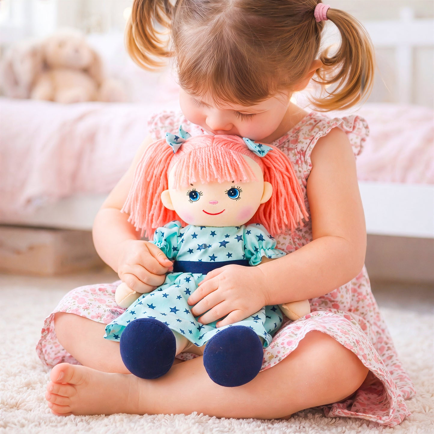 Little girl cuddling and kissing Eva plush doll toy