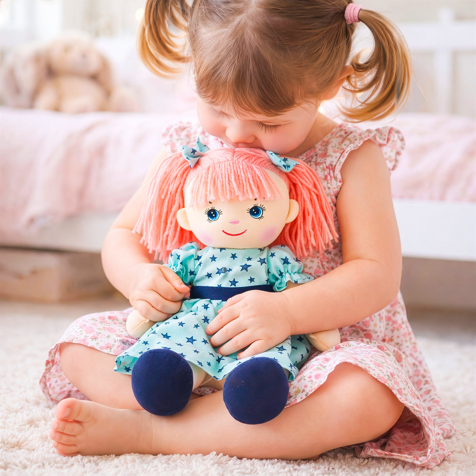 Little girl cuddling and kissing Eva plush doll toy