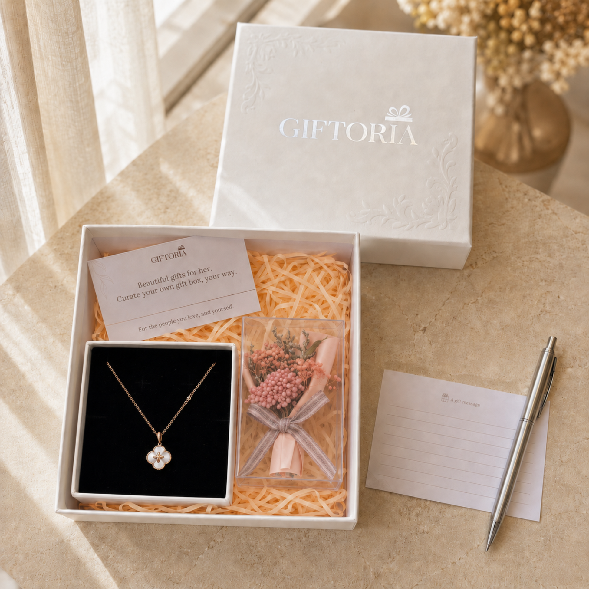 Lucky clover necklace and pink dried flower gift box styled with a message card and pen