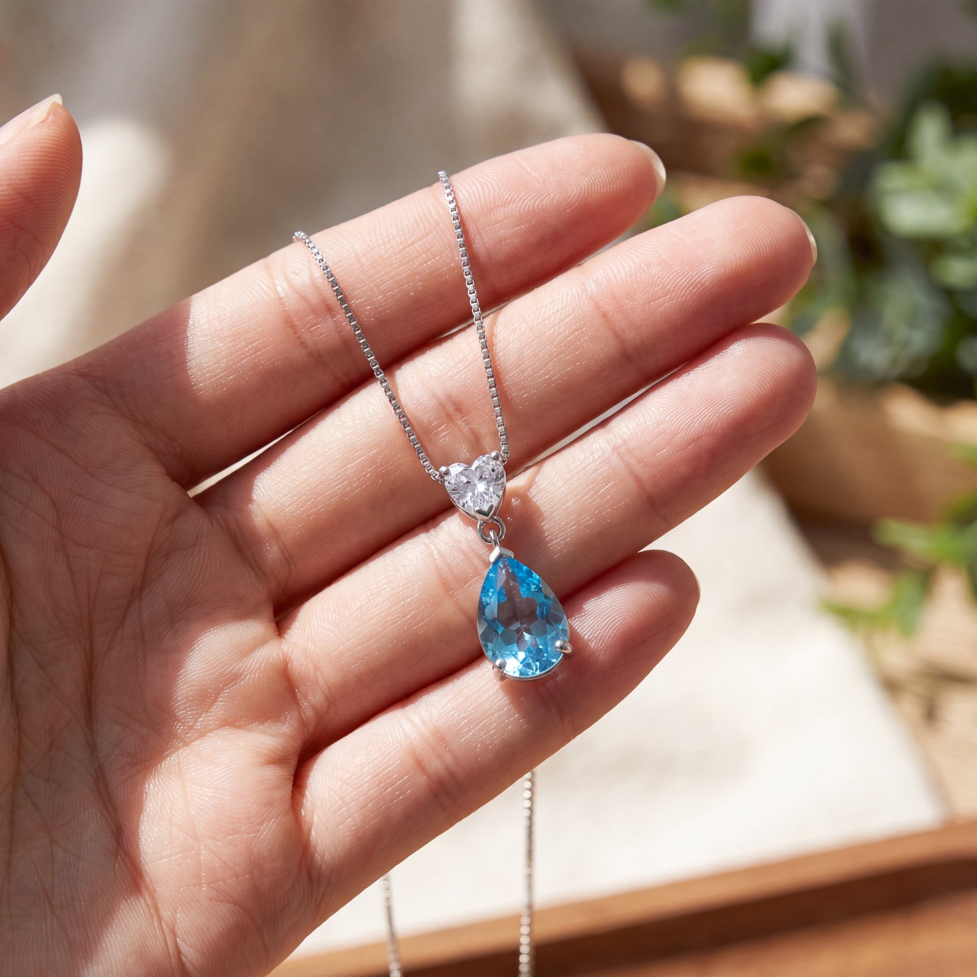 Close up of ocean heart blue necklace held in hand, 925 sterling silver romantic pendant gift for girlfriend or wife