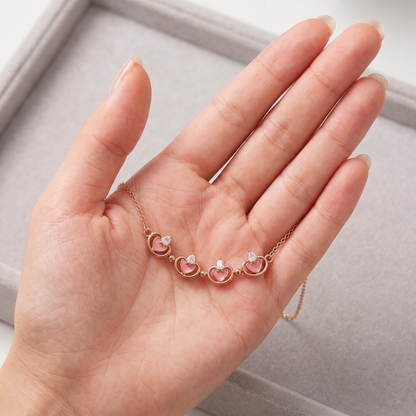 Open rose gold magnetic clover necklace shown on hand