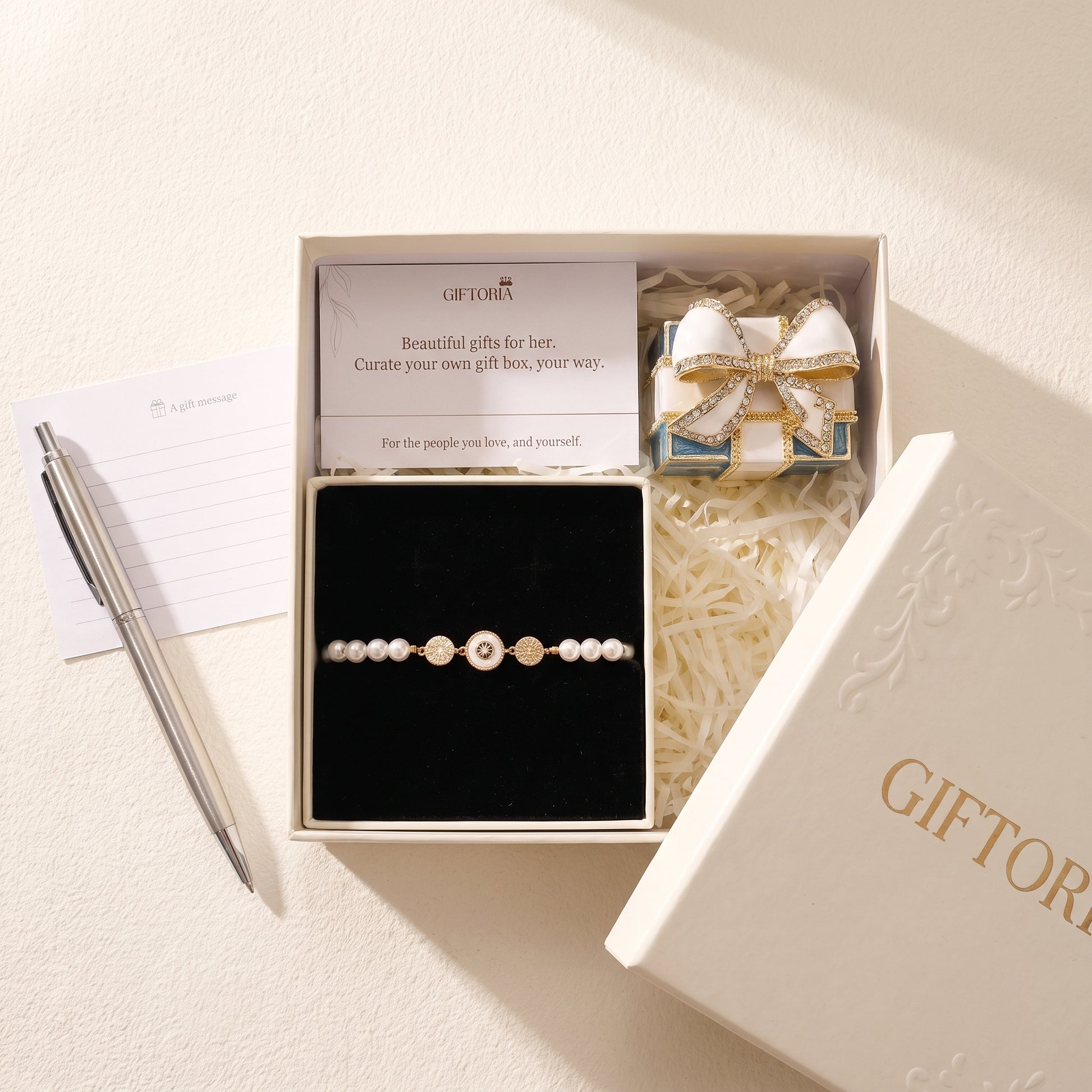 Gold evil eye pearl bracelet gift set beside a personal message card and Giftoria gift box
